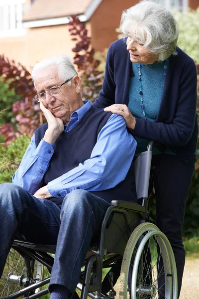 Deprimerade äldre Man i rullstol skjuts av fru — Stockfoto