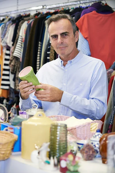 Hombre comprador en Thrift tienda mirando adornos — Foto de Stock