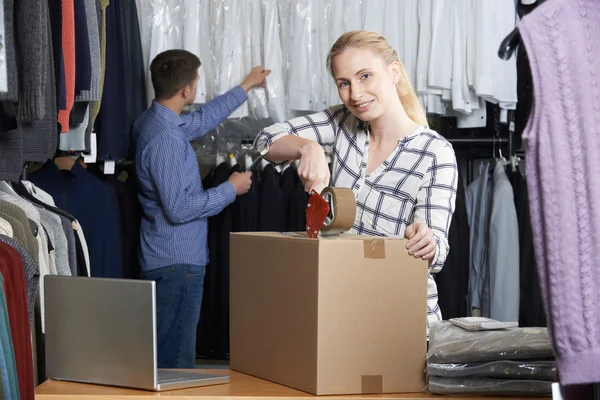 Couple exécutant les marchandises d'emballage en ligne de magasin de vêtements pour l'expédition — Photo