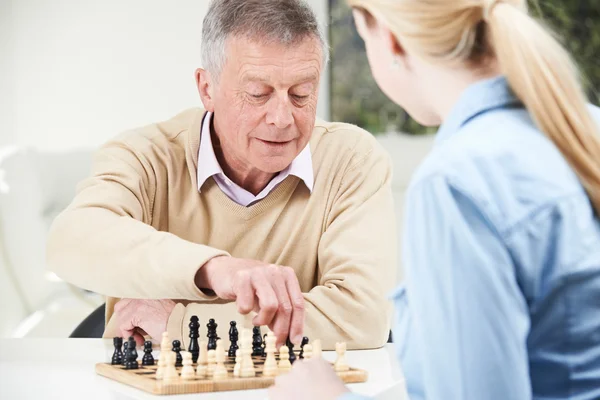 Hombre mayor jugando ajedrez con nieta adolescente — Foto de Stock