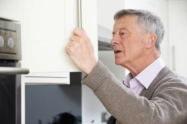 Forgetful Senior Man Looking In Cupboard — Stock Photo, Image