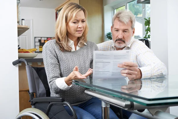 Frustriertes Paar mit Frau im Rollstuhl liest Brief — Stockfoto