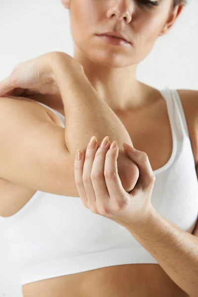 Studio Shot de mujer con codo doloroso — Foto de Stock