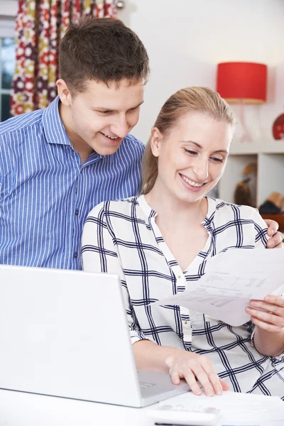 Lächelndes Paar diskutiert zu Hause über die heimischen Finanzen — Stockfoto