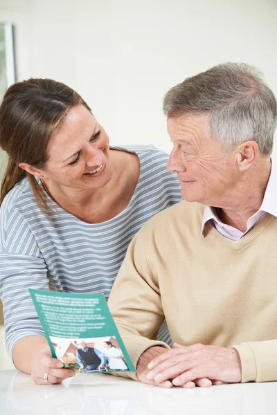 Homme âgé avec fille adulte regardant la brochure pour les retraités — Photo