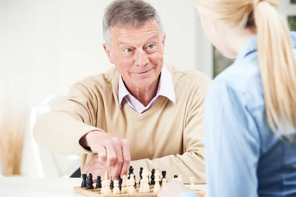 Ανώτερος άνθρωπος παίζει σκάκι με την εφηβική εγγονή — Φωτογραφία Αρχείου