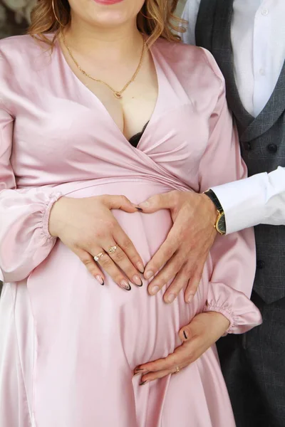 Hamile karnı, anne ve babasının elleri.