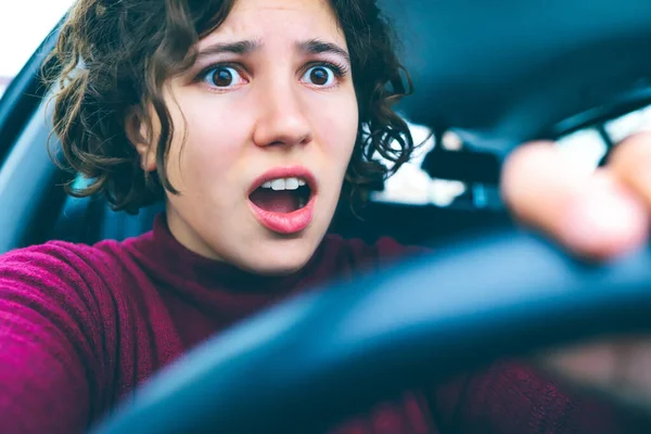 portrait of pretty woman driving car. Frightened face close-up. Crash