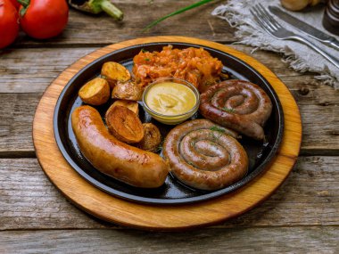 Eski ahşap masada soslu sosisler.