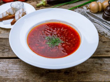 Eski ahşap masada ekşi kremalı borş.