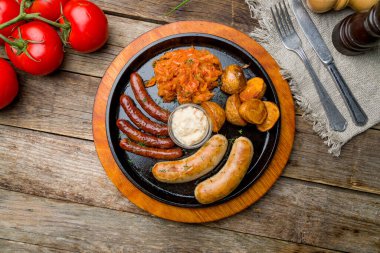 Eski ahşap masada soslu sosisler.