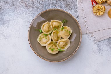 Ekşi kremalı hamur tatlısı ve gri taş masada otlar.