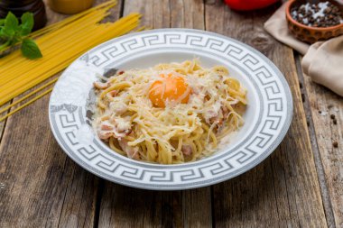 Pastırmalı makarna ve yumurta eski ahşap masada.