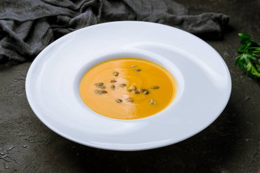 Siyah beton masada balkabağı çorbası kreması.