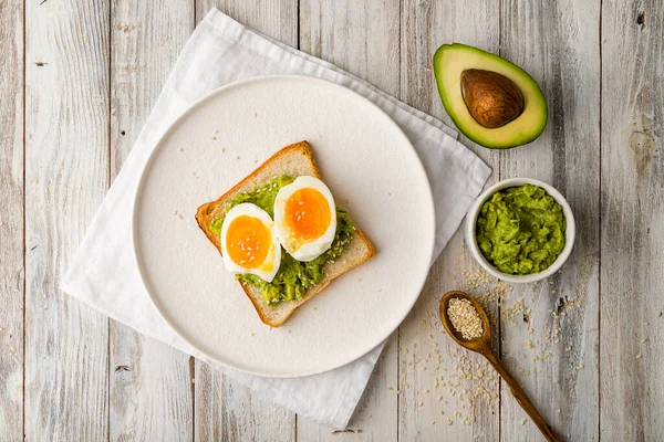 Toast with guacamole and boiled egg, avocado toast. Top view