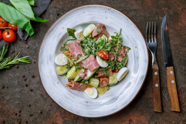 Koyu beton arka planda biftek ve yumurtalı salata.