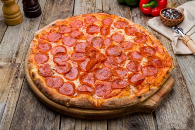 Pepperoni pizzası eski ahşap masada.