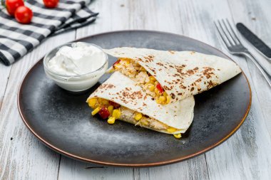 Beyaz ahşap masada tavuklu Meksika Quesadilla 'sı
