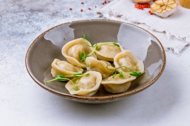 Ekşi kremalı hamur tatlısı ve gri taş masada otlar.