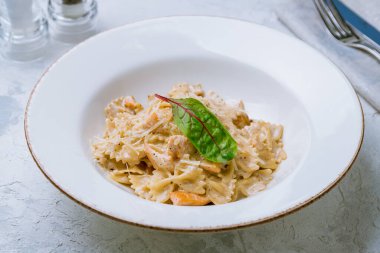 Beyaz tabakta somonlu Farfalle.