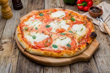 İtalyan pizzası Margherita buffalo domates, mozzarella ve fesleğen ve ahşap masa.
