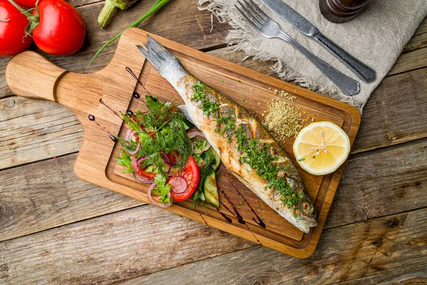 Tahta üstünde kızarmış levrek.