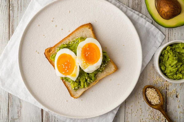 Toast with guacamole and boiled egg, avocado toast. Top view