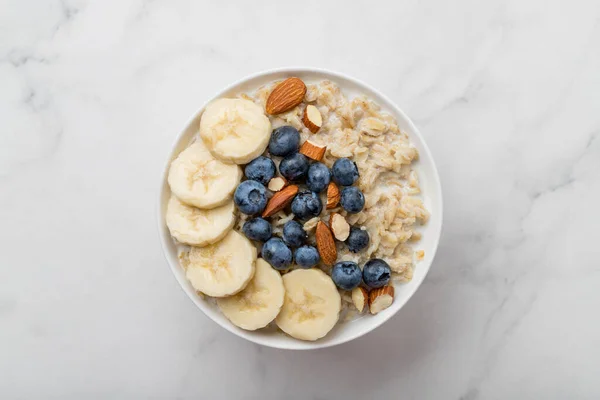 Haferbrei Mit Blaubeeren Mandeln Und Banane Auf Marmortisch — Stockfoto