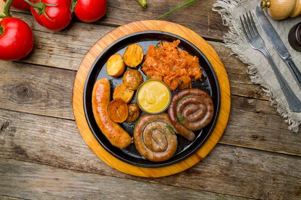 Eski ahşap masada soslu sosisler.