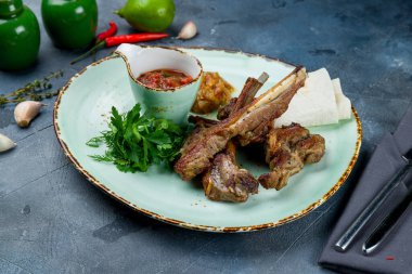 Kuzu pirzolası, gri masada.