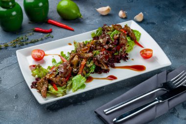 Gri masada biftekli salata.