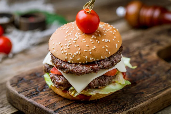 Burger with meat and cheese on wooden table