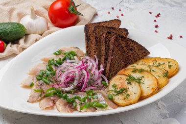 Patatesli ringa balığı, salatalık ve domates. 