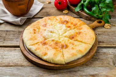 Eski ahşap masada peynirli khachapuri, İmeretian, Gürcü mutfağı.