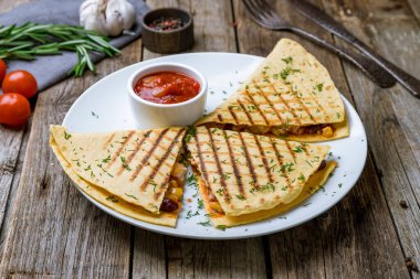 Tahta arka planda tavuk olan Meksika Quesadilla 'sı