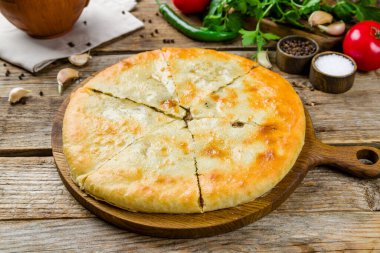 Eski ahşap masada etli Gürcü mutfağı olan Kubdari.