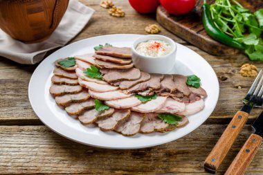 Eski ahşap masada farklı etleri dilimliyorum.