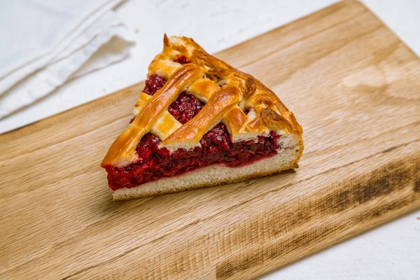 Raspberry pie slice on wooden table
