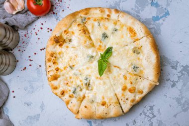 Peynirli ve yapraklı lezzetli pizza, kırmızı domates ve sarımsak. 