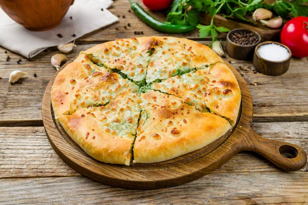 Eski ahşap masada ıspanaklı khachapuri, Gürcü mutfağı.