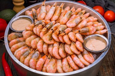 Koyu mavi masada buzda kaynamış karides.