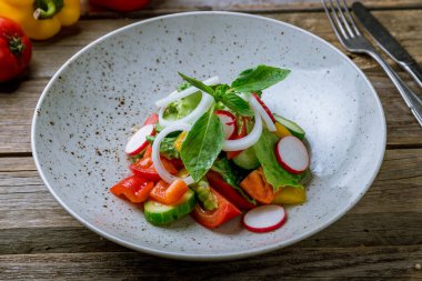Domatesli sebze salatası, salatalık ve eski ahşap masada soğan.