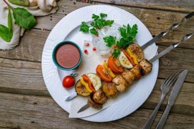 Eski ahşap bir tabakta ızgara sebze ve mantar.