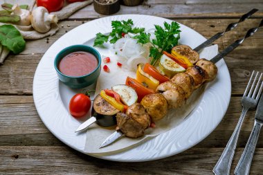 Eski ahşap bir tabakta ızgara sebze ve mantar.