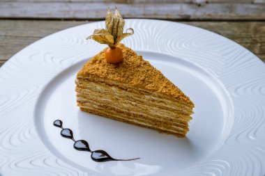 Eski ahşap masanın üzerinde bir parça ballı kek.