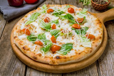 Pizza Sezar ahşap masada.