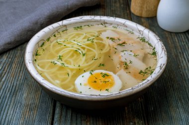 Mavi ahşap tabakta tavuk çorbası.