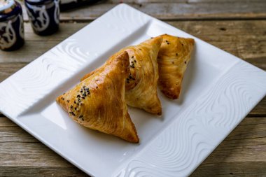 Samsa ulusal Özbek yemeği eski ahşap masada