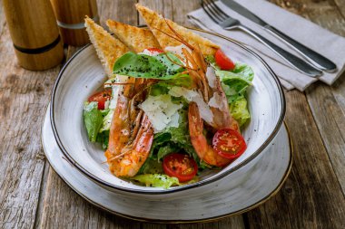 Tahta masadaki karidesli salata sezarı.