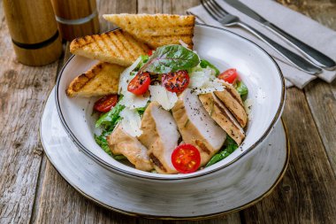 Tahta masada tavuklu salata sezarı.